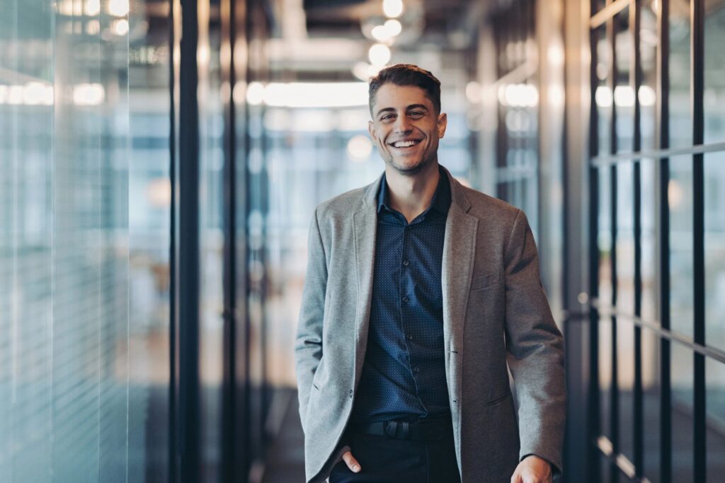 Smiling young man in walking confidently towards the camera