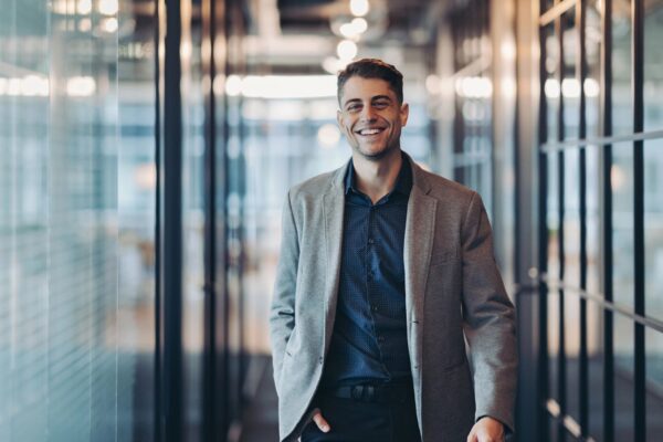Smiling young man in walking confidently towards the camera